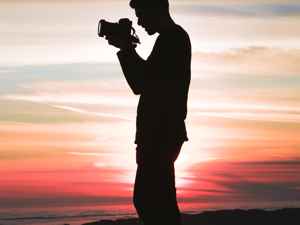 Portrait of the photographer holding a camera in a softly lit studio